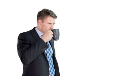 Erkek müdür stüdyoda dururken bir fincan sıcak kahvenin tadını çıkarıyor. Beyaz arkaplanda izole