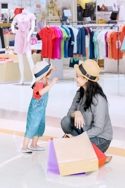 服屋で買い物をしながらお母さんとおしゃべりする女の子 — ストック写真