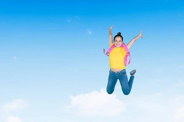 Ευτυχισμένη Μαθήτρια Που Κουβαλάει Ένα Σακίδιο Ενώ Πηδάει Στον Γαλάζιο — Φωτογραφία Αρχείου