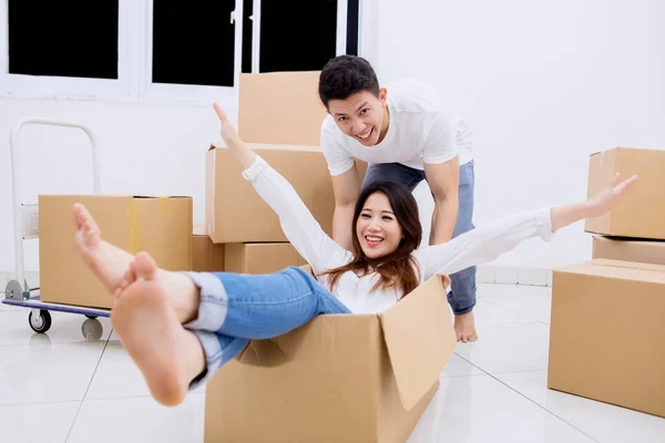 Young Couple Having Fun Unpacking Boxes While Moving New House — Zdjęcie stockowe