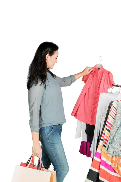 Young Woman Choosing Clothes While Standing Studio Isolated White Background — Stockfoto