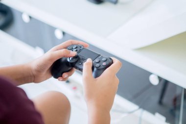 Evde video oyunu oynarken joystick kullanan reşit olmayan çocukların ellerini kapat.