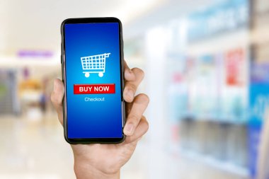 Young woman hand using a shopping online apps on the smartphone with mall background