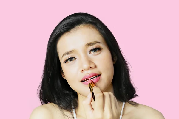 Close Young Woman Applying Pink Lipstick Her Lips While Sitting — Foto Stock