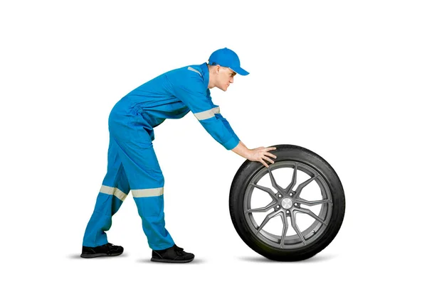 Side View Caucasian Male Mechanic Pushing Car Wheel Studio Isolated — стоковое фото