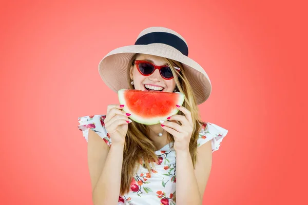 Caucasian Woman Eating Watermelon While Standing Studio Red Background — Stok fotoğraf