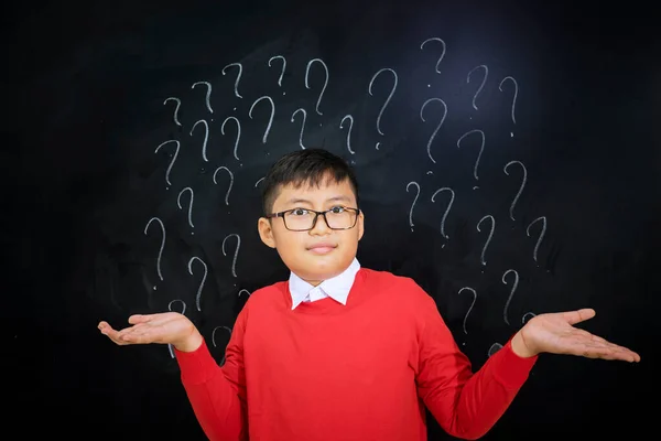 Little Boy Looks Confused While Standing Question Marks Classroom — Stock fotografie