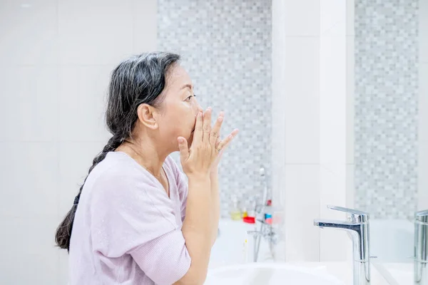 Zijaanzicht Van Oudere Vrouw Die Haar Gezichtshuid Behandelt Terwijl Badkamer — Stockfoto