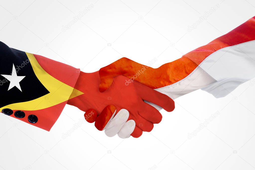 Close up of two hands people handshaking each other with Indonesia and East Timor flag
