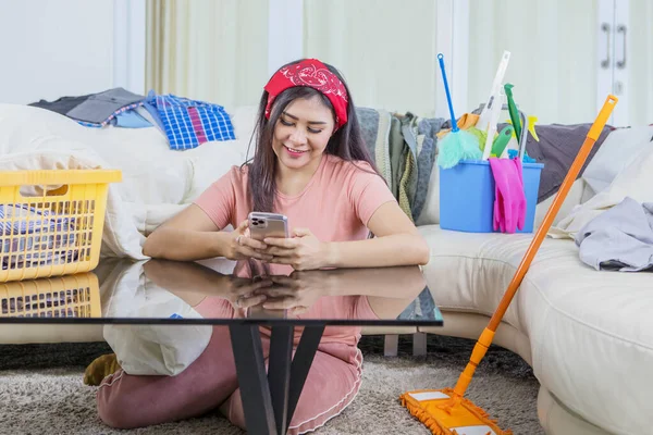 Huishoudster Met Behulp Van Een Mobiele Telefoon Tijdens Het Zitten — Stockfoto