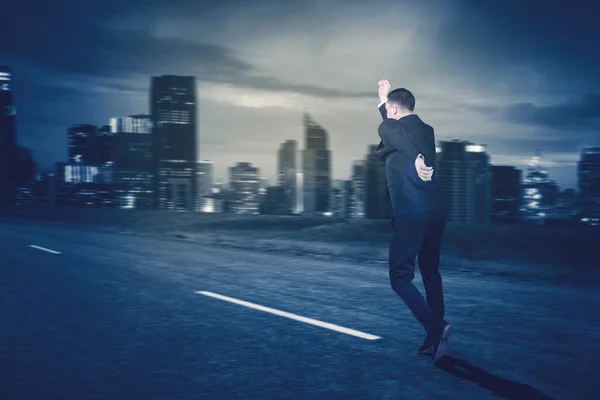 超高層ビルを背景に高速道路を走っている若い実業家の背面図 — ストック写真