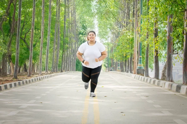 Parkta Koşarken Kameraya Gülümseyen Şişman Kadın — Stok fotoğraf