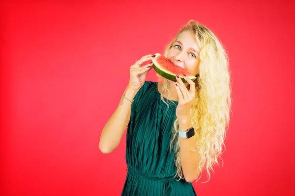 Mulher Loira Comendo Melancia Enquanto Estava Estúdio Com Fundo Vermelho — Fotografia de Stock