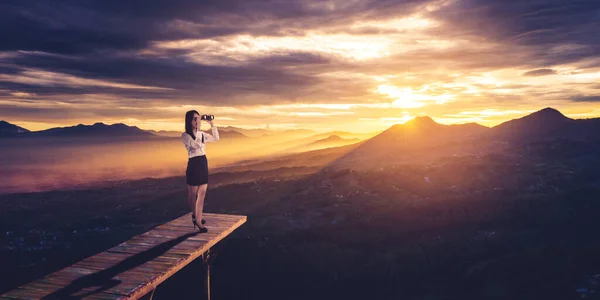 Mladá Podnikatelka Pomocí Dalekohledu Zatímco Stojí Dřevěném Mostě Horským Pozadím — Stock fotografie