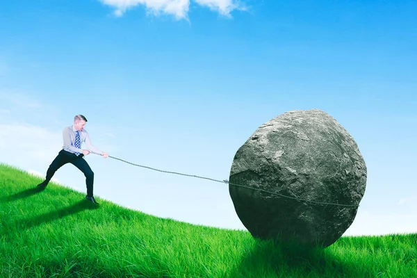 Caucasian Businessman Using Chain Pulling Rock While Climbing Hill Meadow — Stock Photo, Image