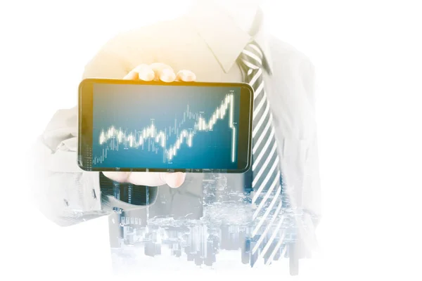 Double exposure of businessman hand showing declining candlestick chart on the cellphone while standing with cityscape background