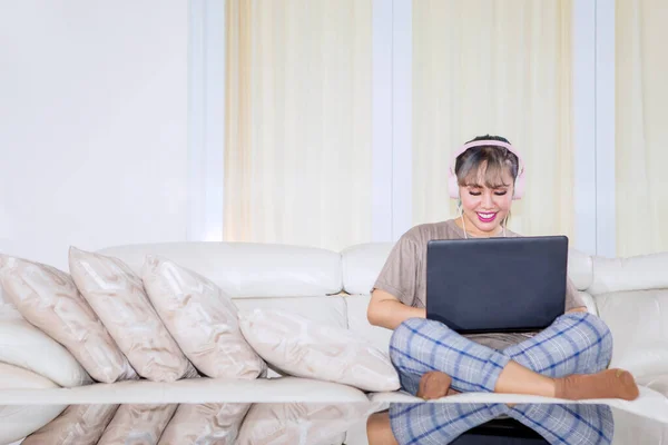 Beautiful Young Woman Using Laptop While Listening Music Headset Couch — Fotografia de Stock