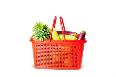 Close up of red plastic basket with fresh vegetables in the studio. Isolated on white background