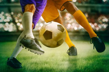 Close up of two soccer players feet competing on the soccer field while intense struggle for the ball
