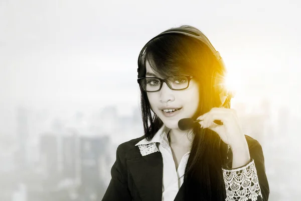 Operatore Call Center Femminile Utilizzando Cuffie Mentre Seduto Con Sfondo — Foto Stock