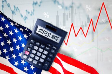 Close up of calculator with interest rate text above America flag with growth finance chart background