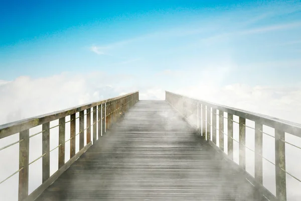 霧の朝に青空の背景を持つ空の木製の橋のイメージ — ストック写真