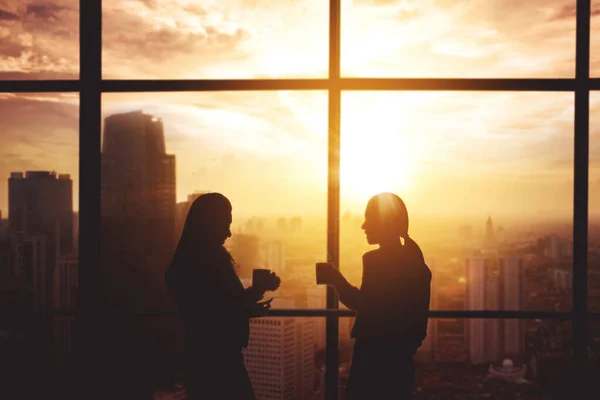 Silhouette Two Businesswomen Enjoying Coffee Time While Standing Window Sunlight — Stockfoto