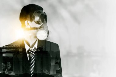 Double exposure of businessman wearing gas mask while looking at copy space with polluted factory background