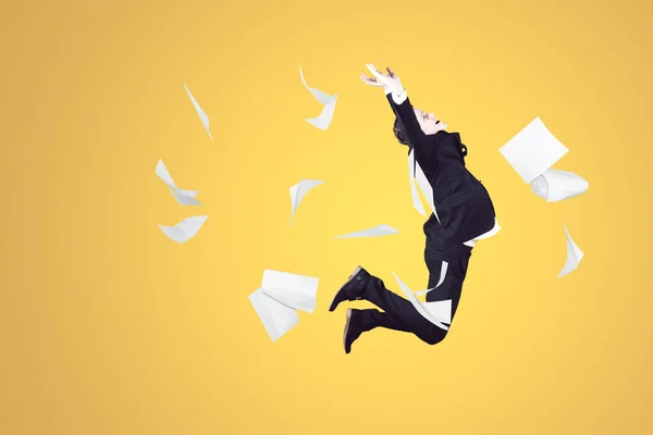 Happy Young Businessman Throwing Documents While Jumping Studio Yellow Background — Stok fotoğraf