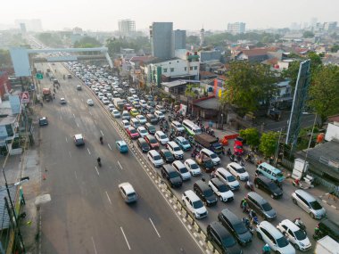 JAKARTA - Indonesia. August 08, 2022: Drone view of numerous motorcycles and cars moving in traffic jam on rush hour at highway