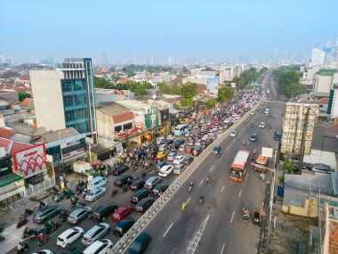 JAKARTA - Indonesia. August 08, 2022: Aerial view of queued motorcycle and cars moving toward bridge at the rush hour in Jakarta city