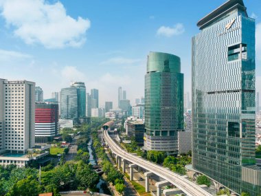 JAKARTA - Indonesia. August 08, 2022: Drone view of river with LRT track surrounded skyscraper in Jakarta city