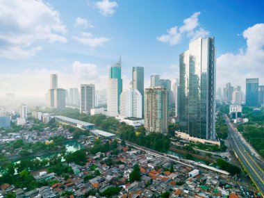 JAKARTA - Indonesia. August 15, 2022: Drone view of residential rooftop with highrise buildings in Jakarta city at morning time