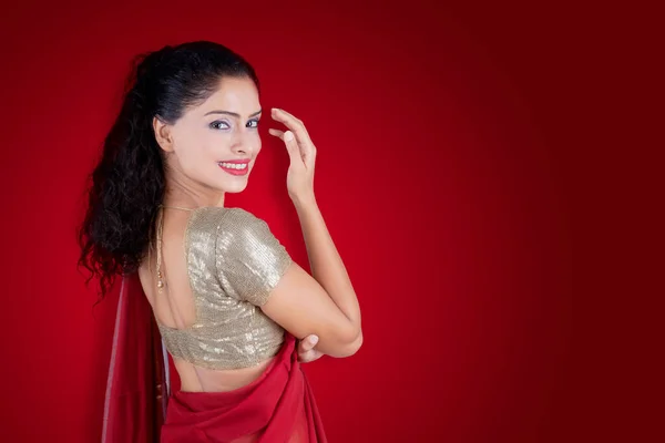 Widok Tyłu Indianki Ubranej Czerwone Sari Podczas Uśmiechu Kamery Studio — Zdjęcie stockowe