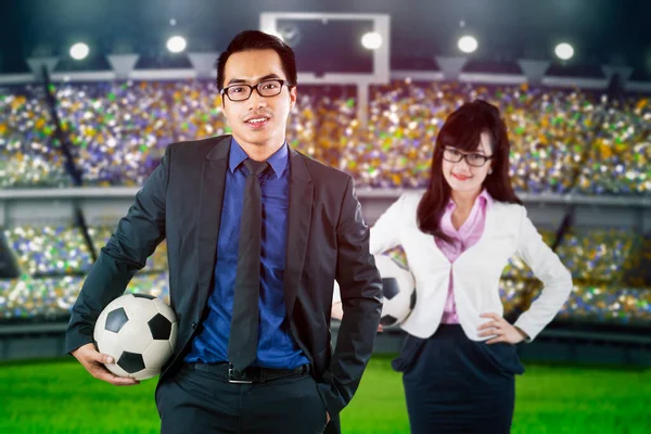 Two Business People Holding Soccer Ball While Standing Stadium Spectators — Stock Photo, Image