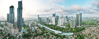 JAKARTA - Indonesia. August 15, 2022: Beautiful panoramic view of suburban houses with skyscraper background in Jakarta downtown at morning time