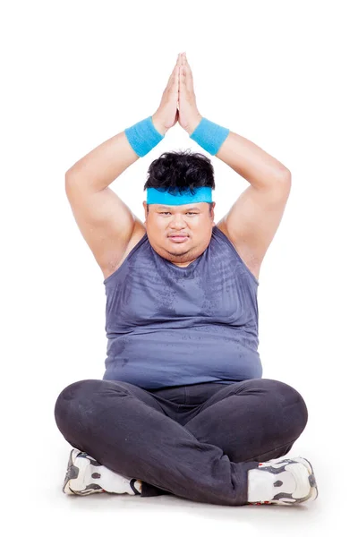 年轻的胖子在工作室做瑜伽练习时举起了手 因白人背景而被隔离 — 图库照片