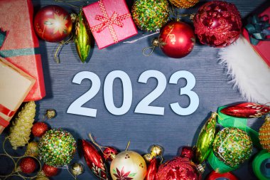 Mutlu yıllar konsepti. Hediye kutularının ve üzerinde 2023 numara olan Noel süslerinin en üst görüntüsü
