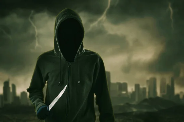 Hooded Man Hålla Kniv När Står Med Grumlig Himmel Bakgrund — Stockfoto