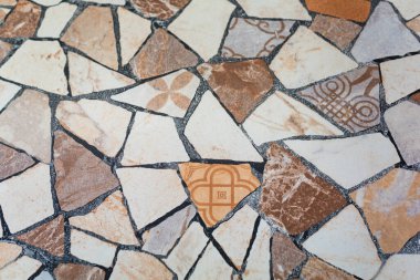 Farklı tasarımı ile eski ve kısmen hasarlı kare kiremit yüzeyi.