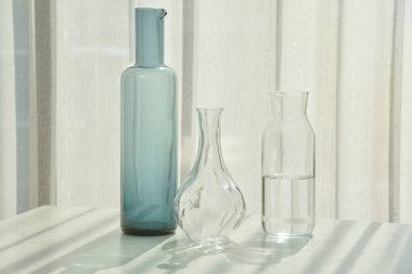 Cam eşyalar güneş ışığı gölge efektini yansıtır, yaz durgun hayat sahnesi, şeffaf, parlak su bardakları, güneşli bir günde ılık ışık titreşimleri..