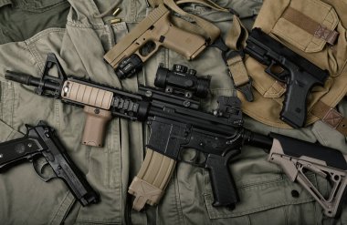 BANGKOK, THAILAND - 3 Nisan 2022: Colt 'un ordu için M4A1 silahları ve askeri teçhizatı, kamuflaj arka planında saldırı tüfeği ve tabanca.