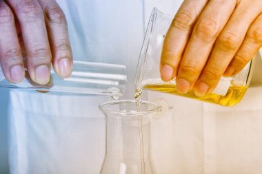 Chemical reagent pouring and mixing, Laboratory and science experiments, Oil formulating the chemical for medical research.