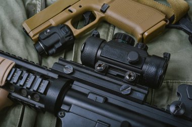 Ordu için silah ve askeri teçhizat, saldırı tüfeği (M4A1) ve yeşil haki üzerine 9mm tabanca.