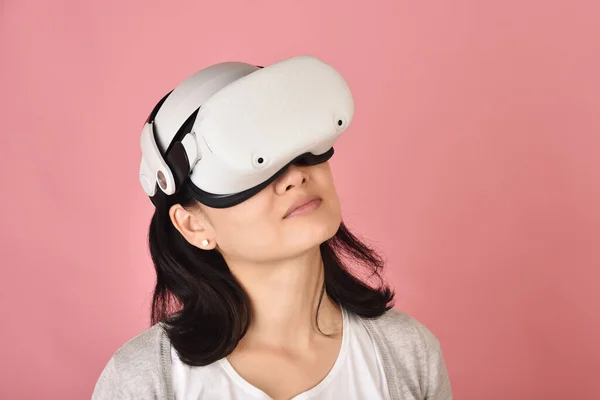 Asian woman using vr glasses, Watching movie and playing video games from virtual reality headset, Young woman amazing with new experience by vr technology, Studio shot.