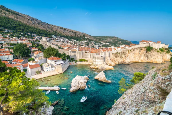 Eski şehir Dubrovnik Panoraması. Kasaba çatıları, denizin üzerindeki uçurum ve tekneli küçük liman..