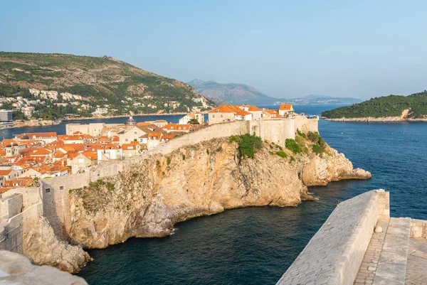 Eski şehir Dubrovnik Panoraması. Kasaba çatıları, denizin üzerindeki uçurum ve tekneli küçük liman..