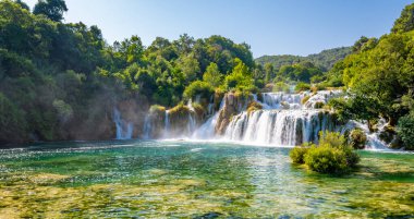 Skradinski Buk 'taki şelaleler, Hırvatistan' daki ulusal doğa parkı Krka. Güzel doğada akan sular, yeşil bitkiler ve ağaçlar. Güneşli yaz günü.