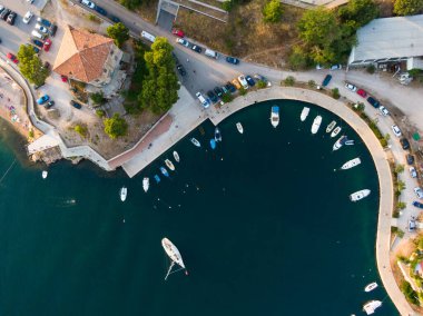 Sibenik şehir limanı, Hırvatistan 'a insansız hava aracı görüntüsü. Tekneleri ve yatı olan deniz suyu. Deniz kenarında yürüyüş yolu.