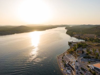 Hırvatistan 'ın Sibenik kenti yakınlarındaki Kornati adaları üzerinde gün batımını gösteren hava aracı görüntüsü. Tekneli su deposu. Yumuşak güneş ışığı..